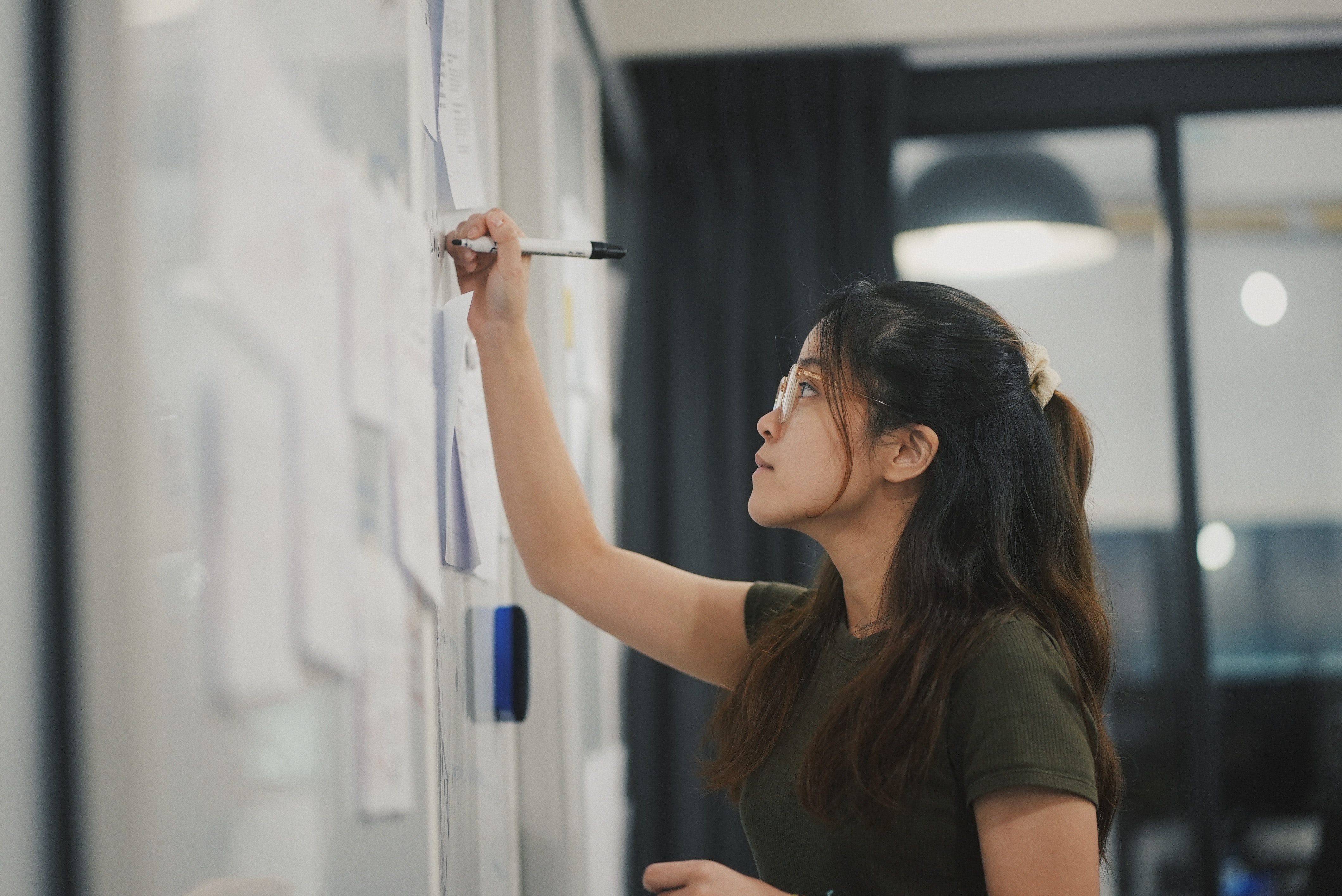 person standing, writing on a whiteboard